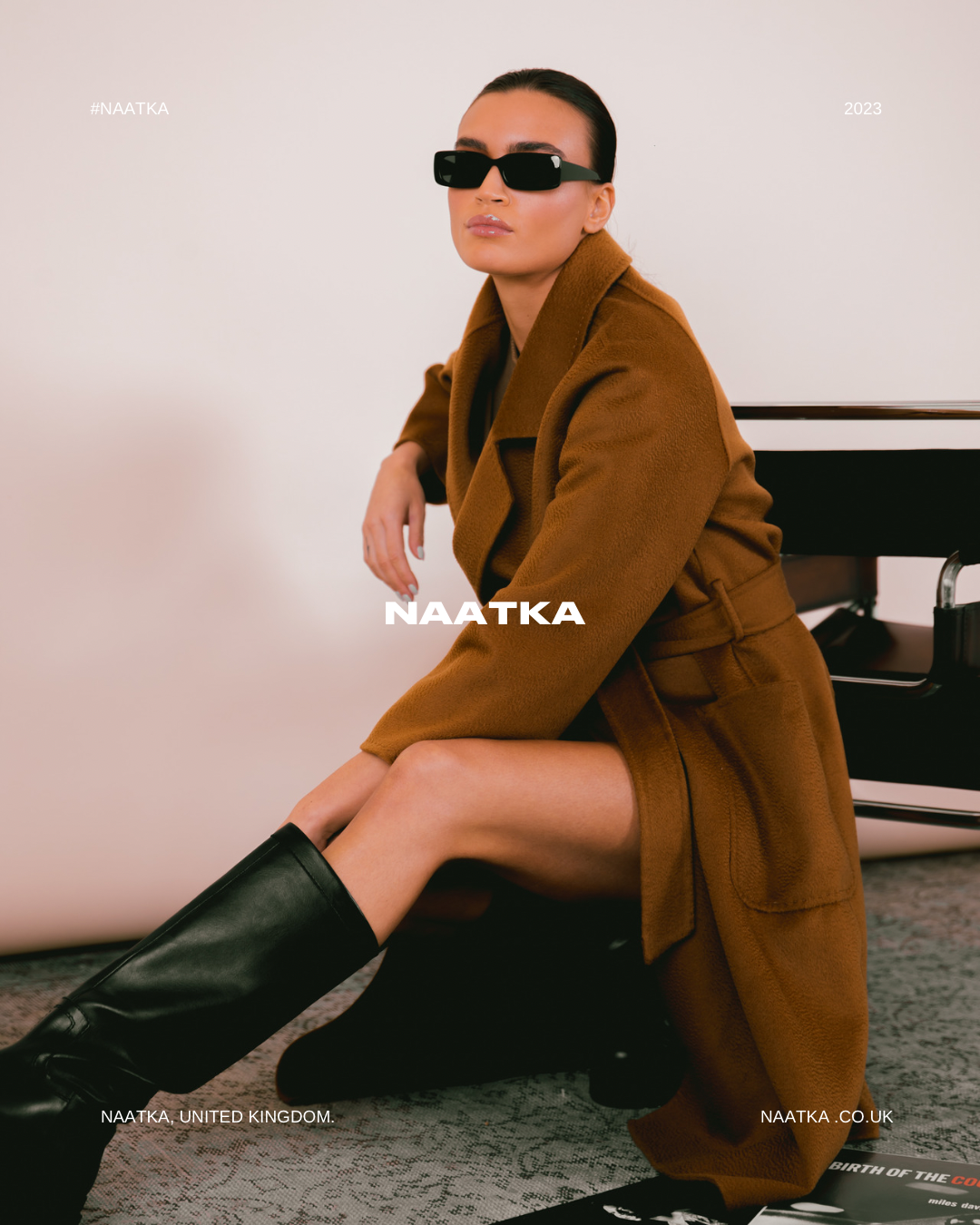 a woman in a brown cashmere coat and black boots.